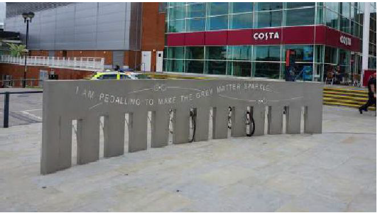 Aylesbury town centre, cement bike stand with words "I'm pedalling to make the grey water sparkle" along the side.
