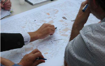 Image of several people pointing and discussing a map